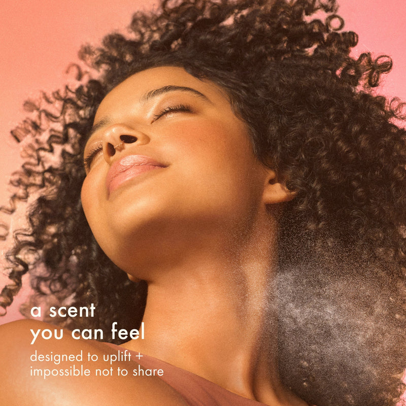 image of a model spraying the mist on hair neck and hair. text: "a scent you can feel" and " designed to uplift + impossible not to share"