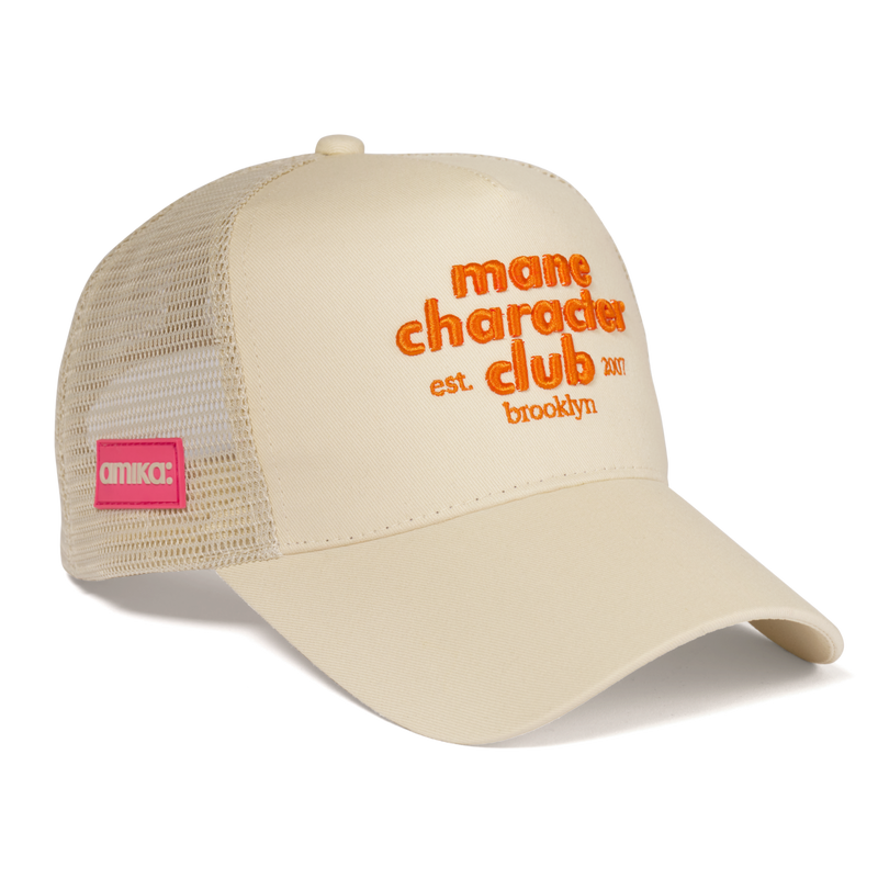 beige cap with orange text. text reads 'mane character club est brooklyn 2007' on a transparent background.